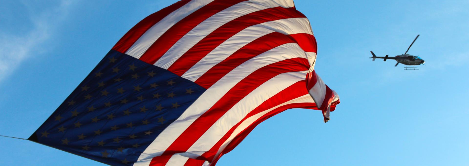 American flag with helicopter in background