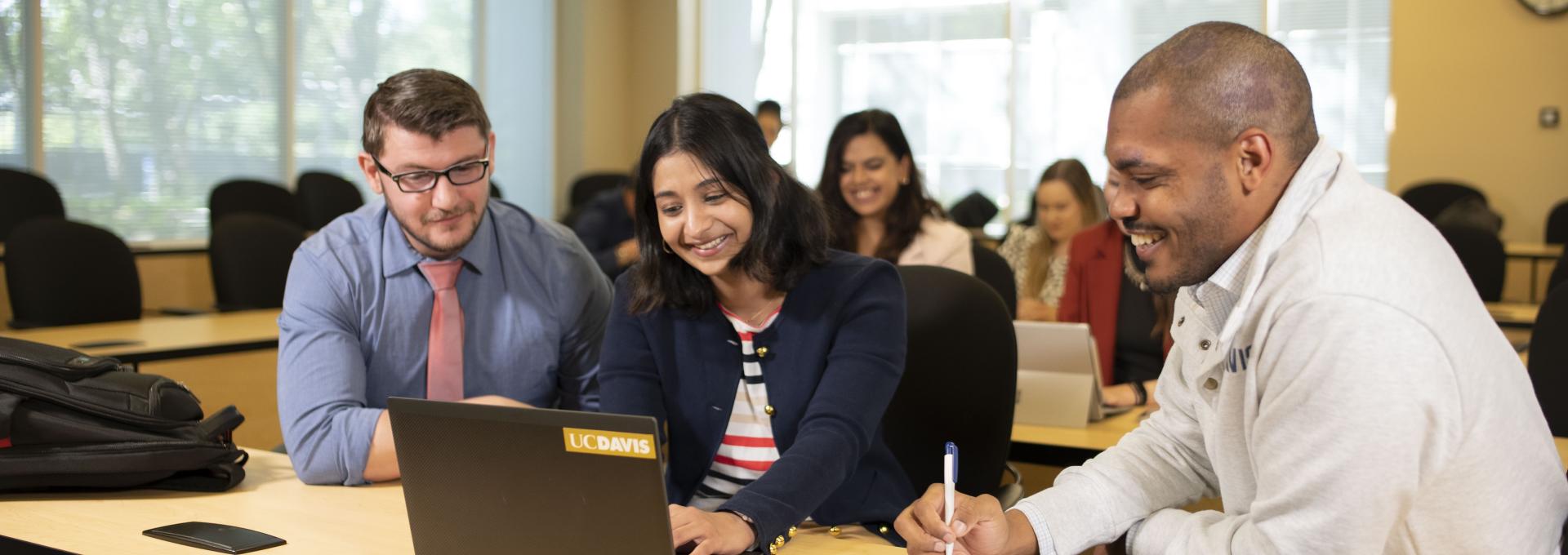 Group of people looking at a laptop