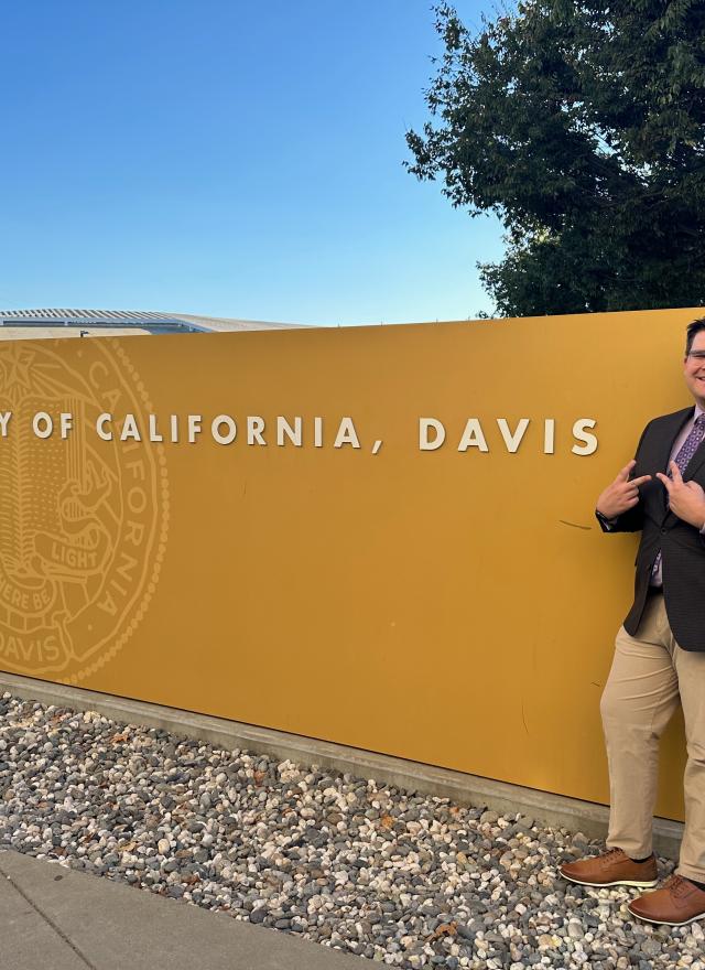 Alex Schultz in front of UC Davis sign